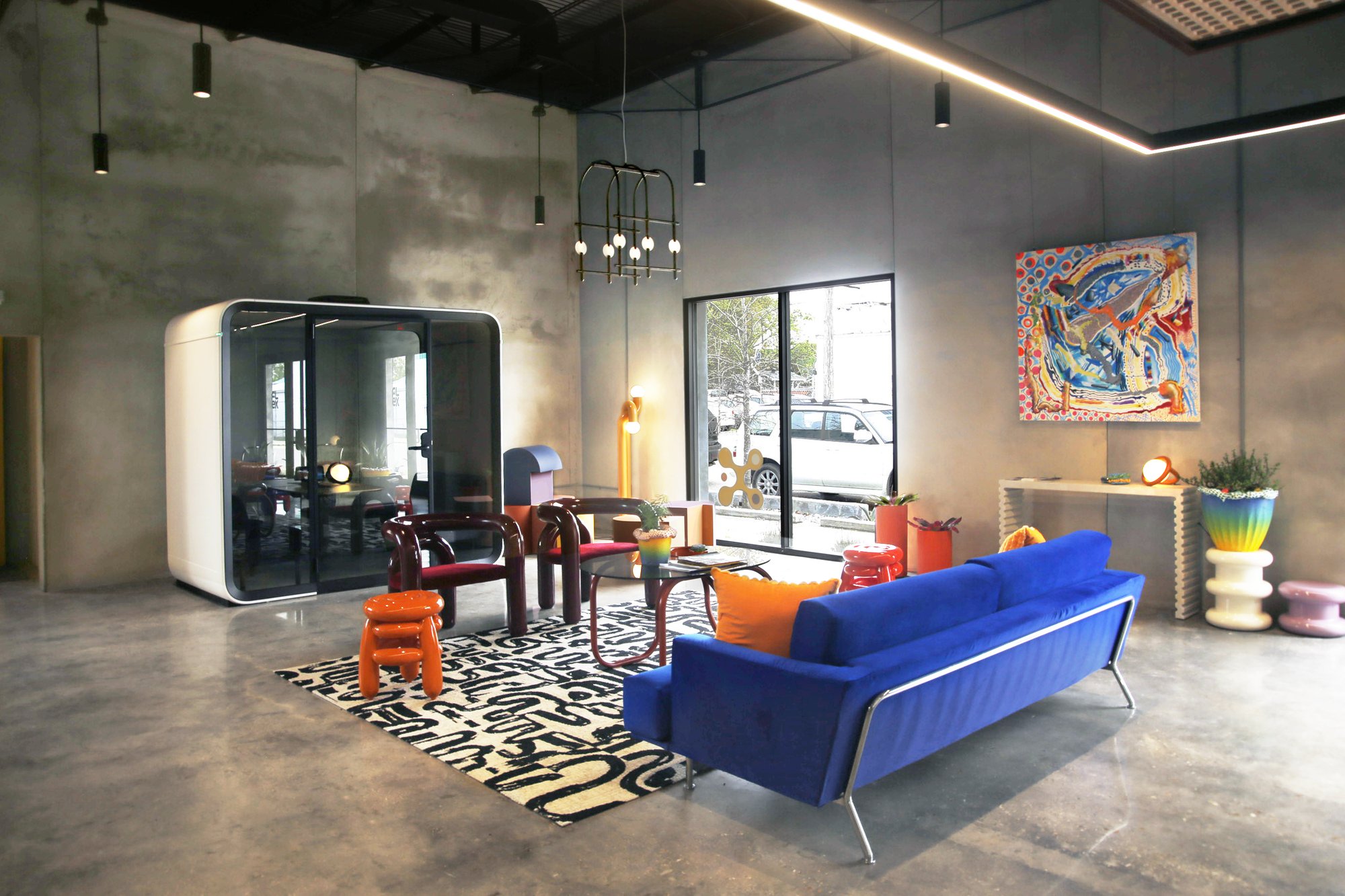 Flex Design Studio New Orleans HQ — lounge with blue velvet sofa, acoustic phone booth, and abstract art