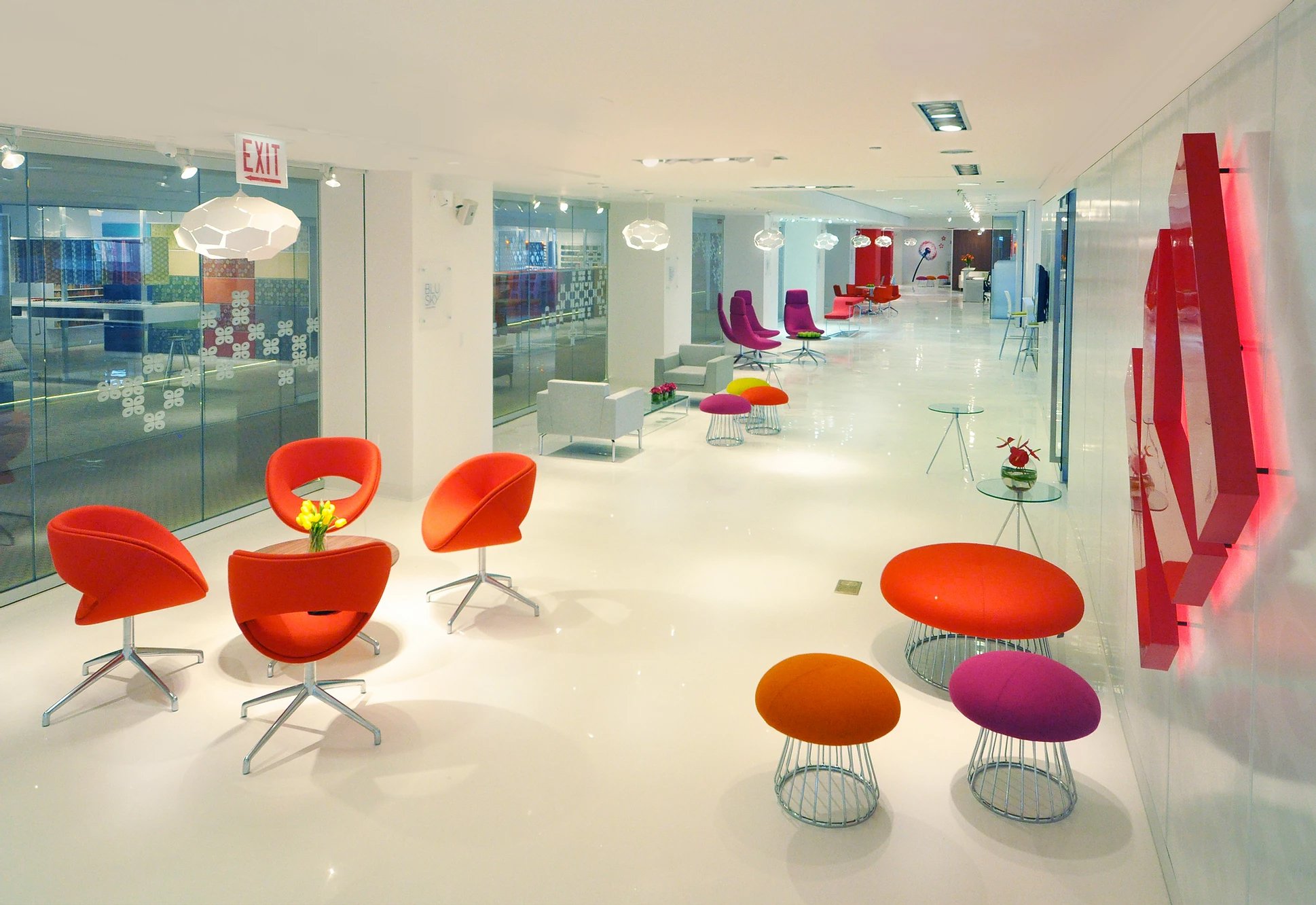KI Showroom — bright lounge corridor with colorful lounge chairs and red wall sculpture